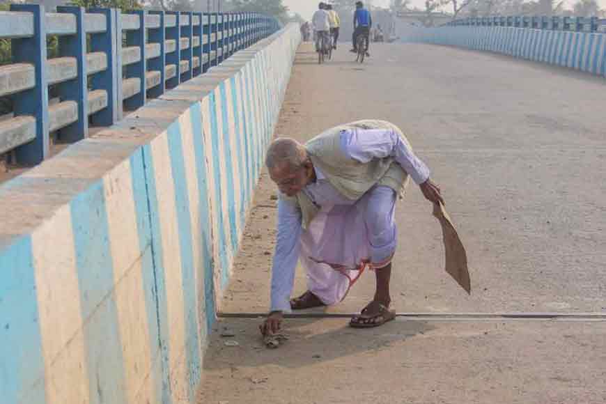 Septuagenarian headmaster cleans Churni bridge single-handedly